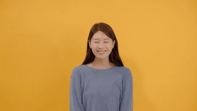 Long haired woman smiling and happy in gray sweater