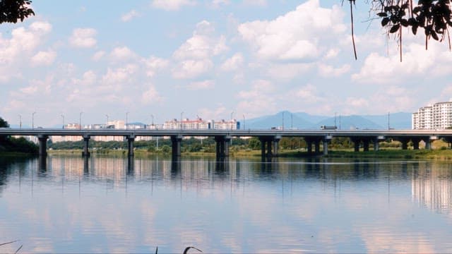 Tranquil River Scene with Bridge and Cityscape