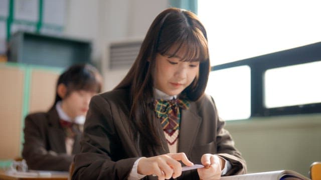 Student studying by sharpening pencils in classroom