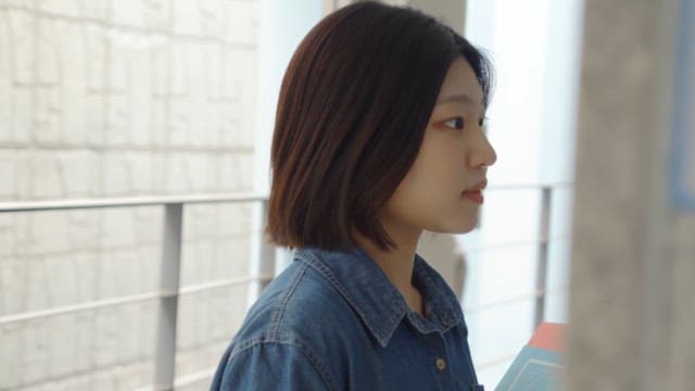 Woman holding a book straightening her hair