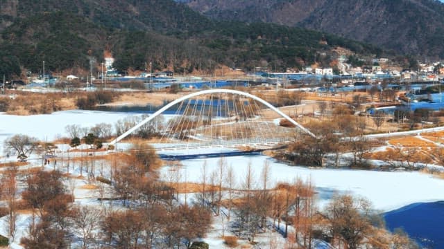 Winter Scene with Snowy Bridge and Icy River