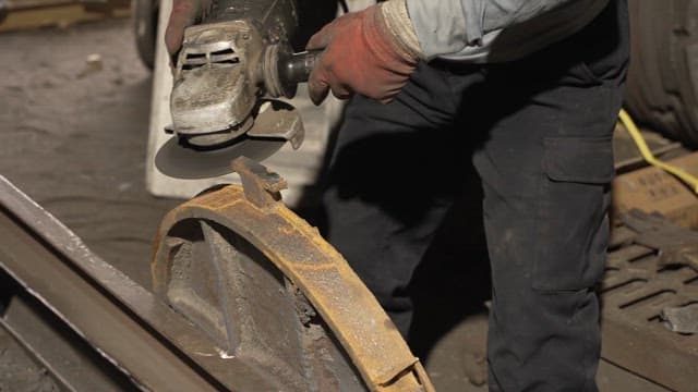 Worker grinding metal with sparks flying