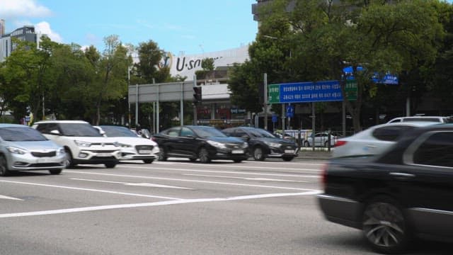 Cars driving on a crowded road on a sunny day