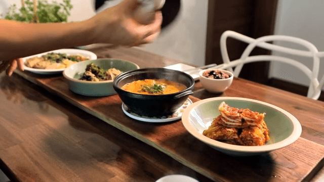 Setting a table with traditional korean food in a cozy kitchen