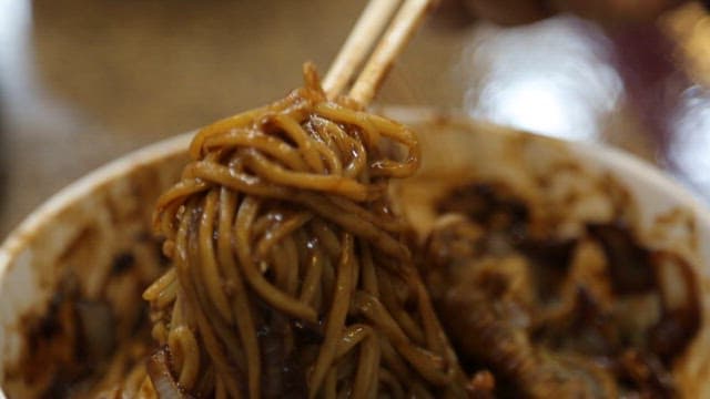 Close-up of noodles being picked up with chopsticks