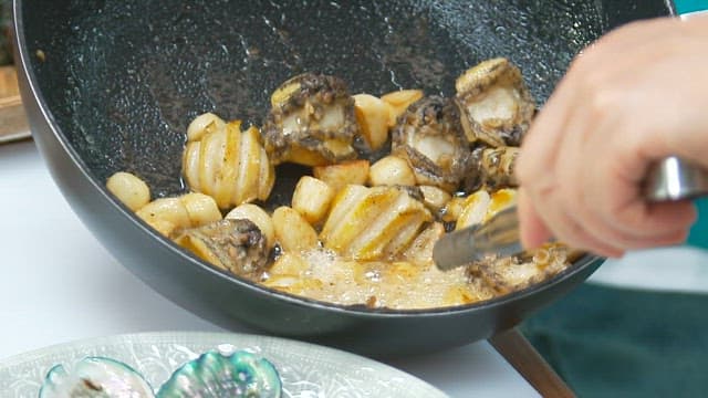 Pan-cooked garlic and abalone plated on a plate