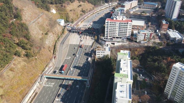 Highway between buildings and mountains