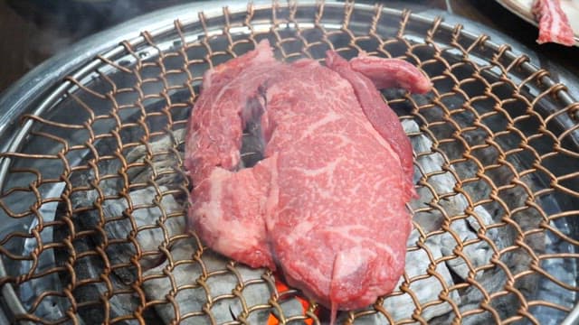 Grilling marbled meat on a barbecue