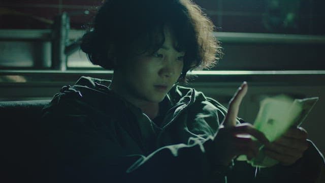 Woman counting money in a dimly lit room