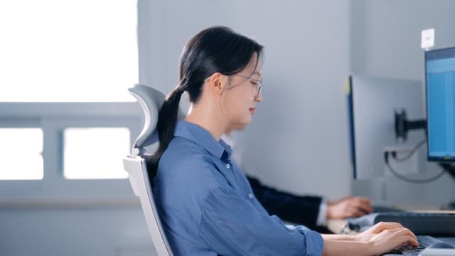 Woman wearing glasses smiling while working in the office