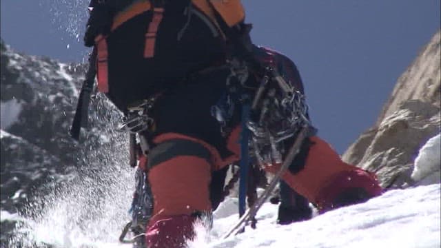 Climber Ascending a Snowy Mountain Slope