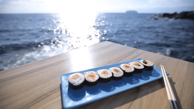 Gimbap on a table by the ocean
