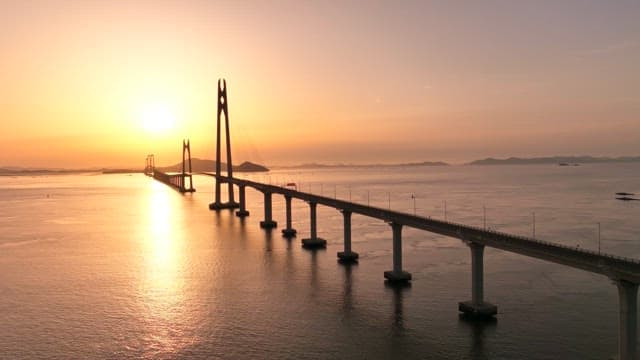 Bridge over calm waters at sunset
