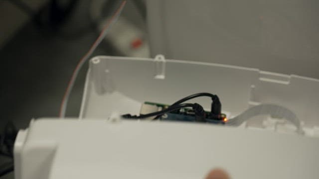 Small electronic device with connected wires inside a white plastic casing