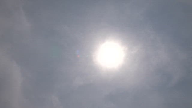 Sun shining brightly through the cloudy sky