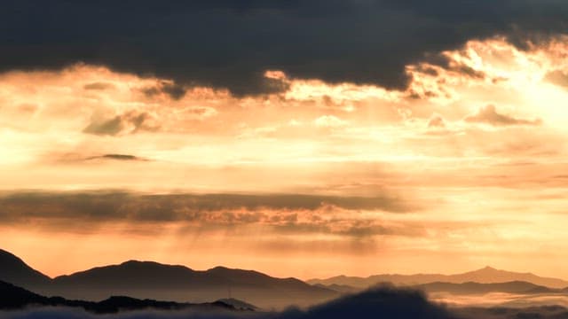 Sunset over mountains with clouds