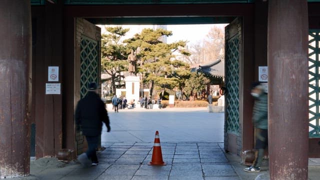 Traditional Korean gate with people passing