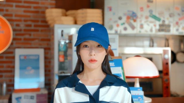 Woman wearing an expressionless blue hat in a pizza shop
