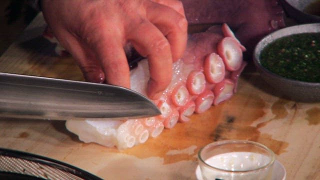 Slicing Octopus on Wooden Cutting Board