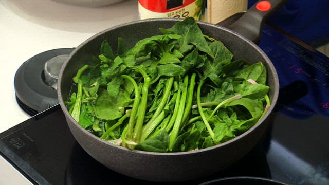 Fresh spinach being cooked in a pan