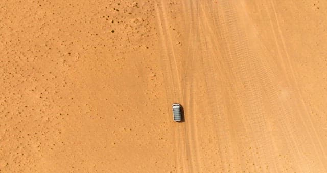 Vehicle traveling through a vast desert