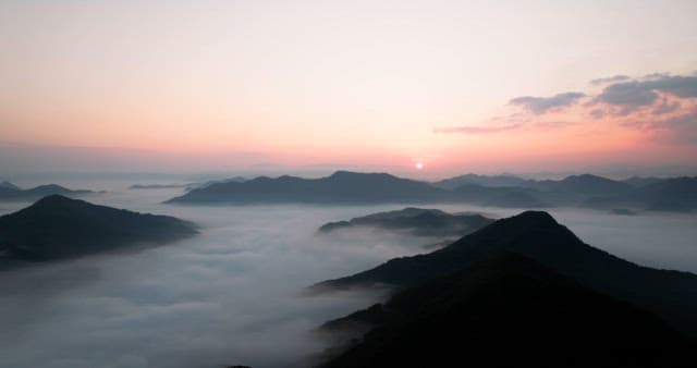 Sky Colored by Sunrise over Foggy Mountains