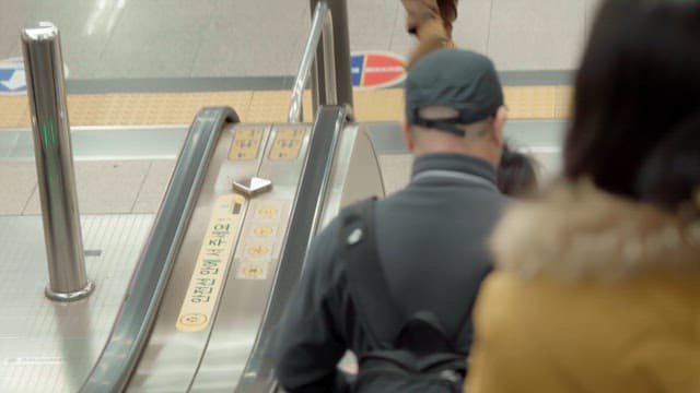 People descending an escalator in a subway