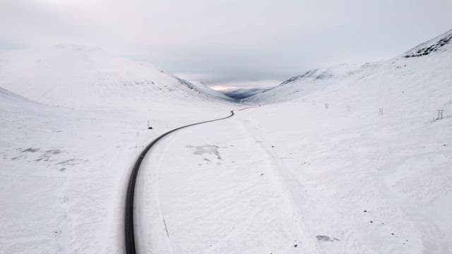 Winding road through snowy mountains