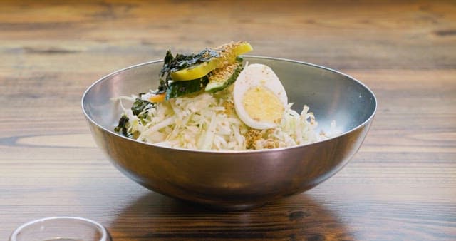 Pouring Soy Sauce on Noodles Filled with Fresh Vegetables