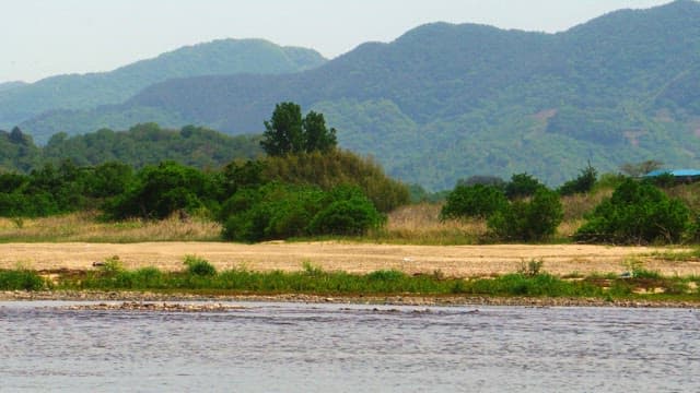 Lush green mountains and tranquil riverbank