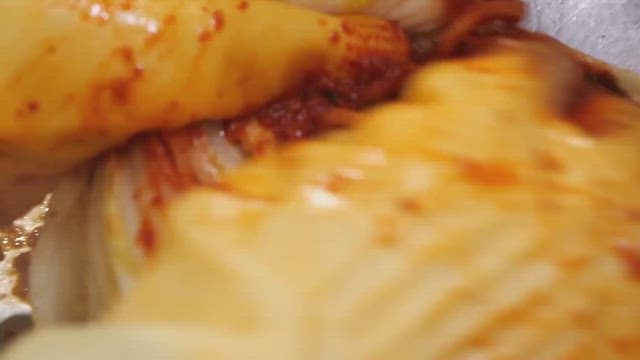 Making kimchi by adding chili pepper seasoning to cabbage