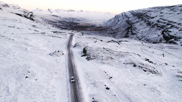 Car driving through a snowy mountain pass