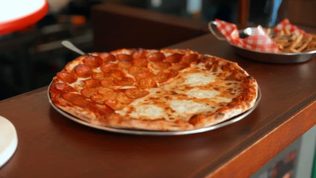 Freshly baked pepperoni pizza being served