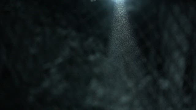 Dust blowing through the dim light in a dark coal mine