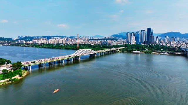 Bridge over a river with a city skyline