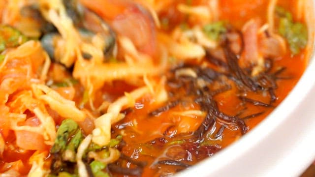 Stirring cold raw fish soup with chopsticks