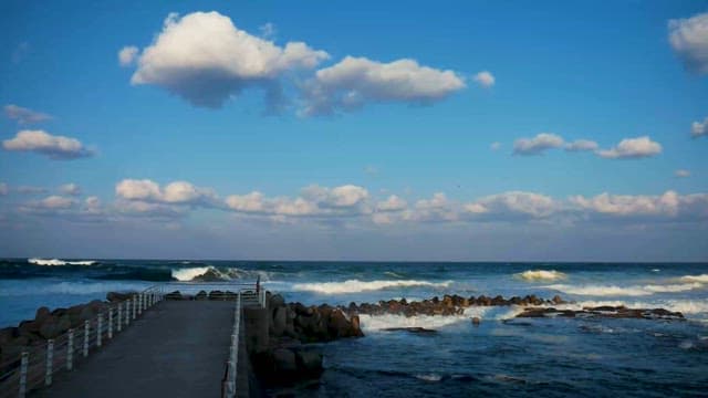 Serene Seascape with Pier and Rocky Shore