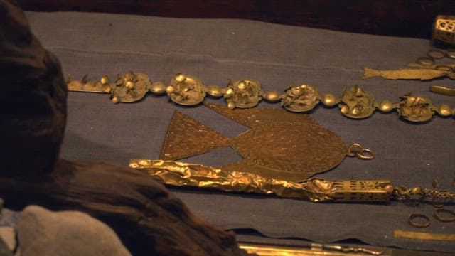 Ancient golden jewelry displayed under dim light