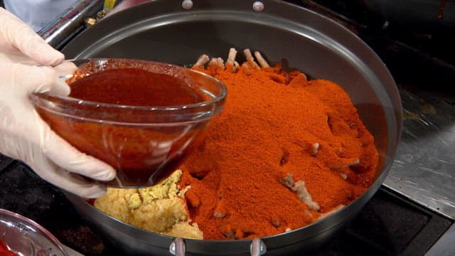 Add seasoning and chili powder to the meat in the frying pan.