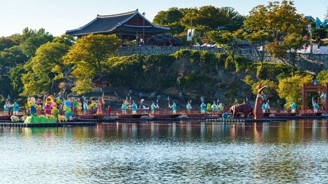 Riverside of Jinjuseong Fortress scenery with trees and colorful lanterns on a sunny day