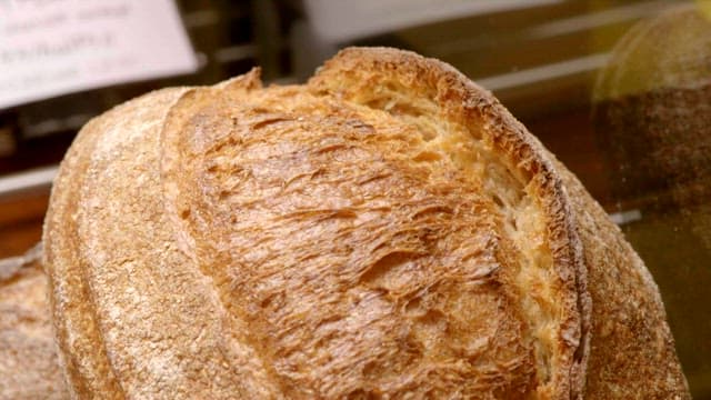 Detailed texture of handmade sourdough bread on display in a bakery