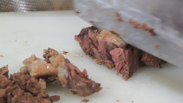 Slicing cooked meat on a cutting board
