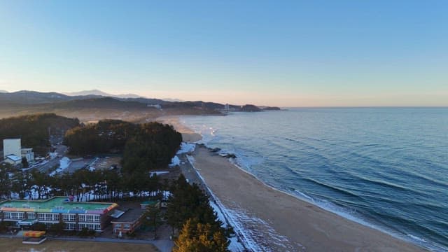 Serene beach with waves and distant mountains
