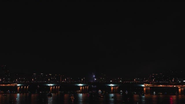 Fireworks over a city bridge at night