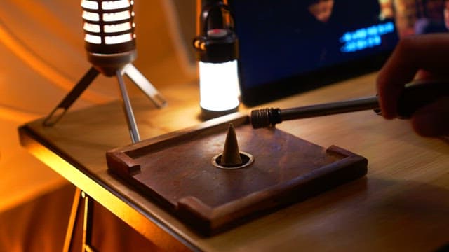 Lighting an incense cone on a wooden stand