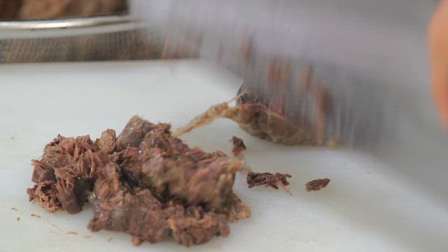 Slicing cooked meat on a cutting board