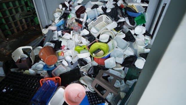 Piles of discarded plastic containers in a recycling facility