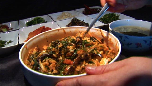 Mixing bibimbap ingredients in a bowl