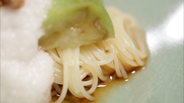 Bowl of buckwheat soba topped with natto and grilled eggplant
