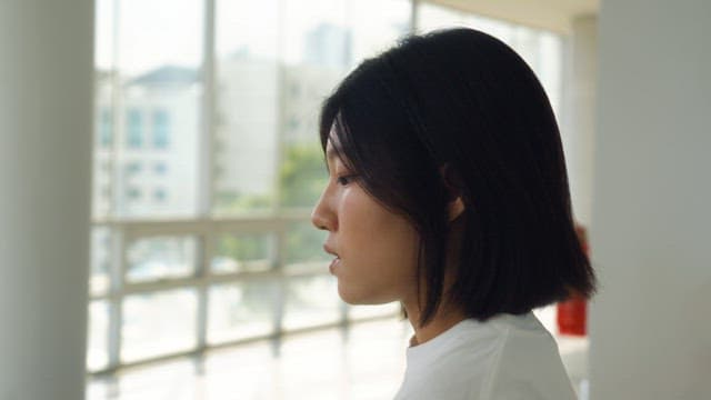 Woman sighing while sitting on a bench indoors